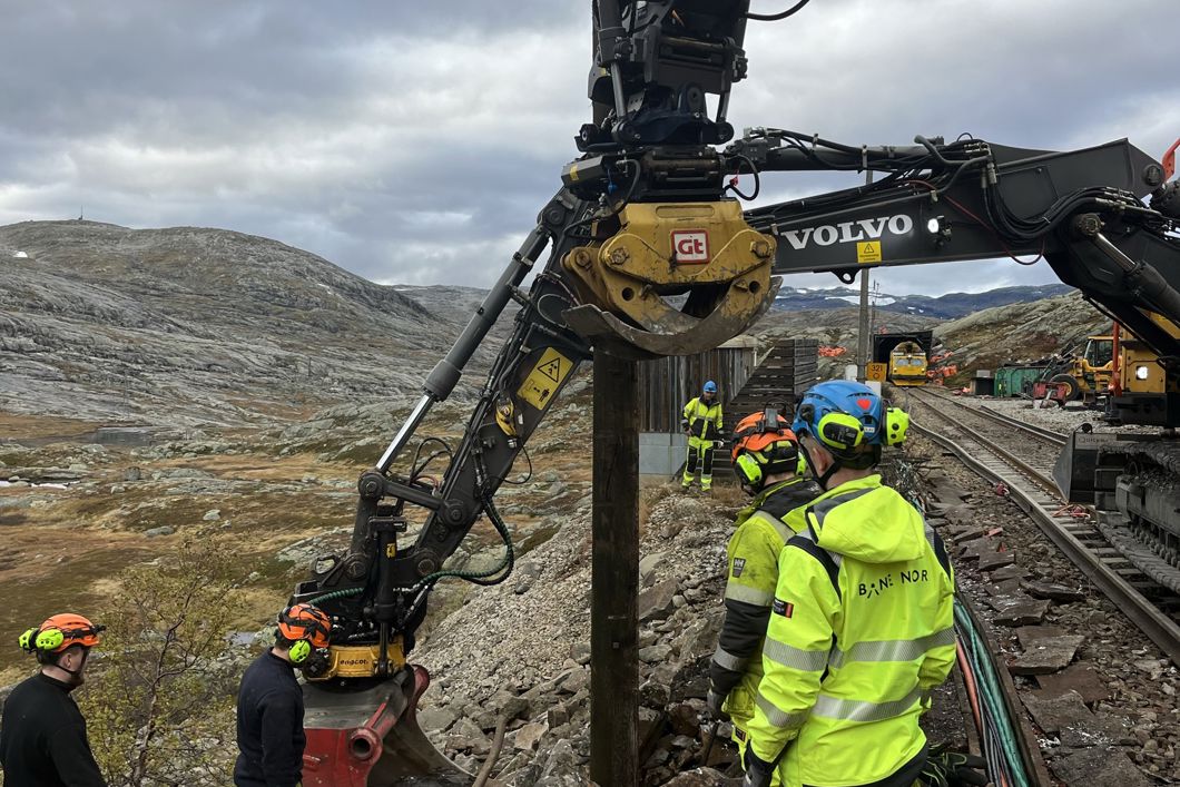 Gul arbeidsmaskin jobber på jernbanesporet