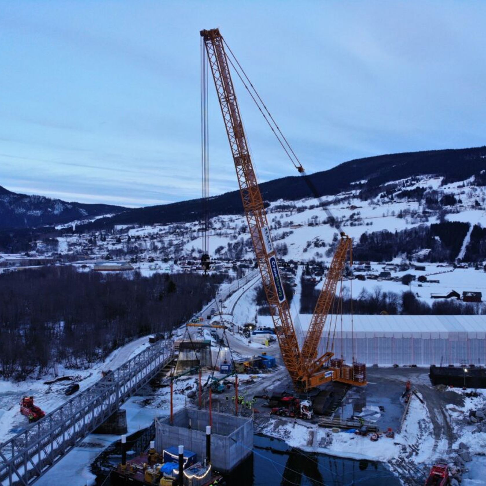 Stor kul kran heiser senkekasse mot brua