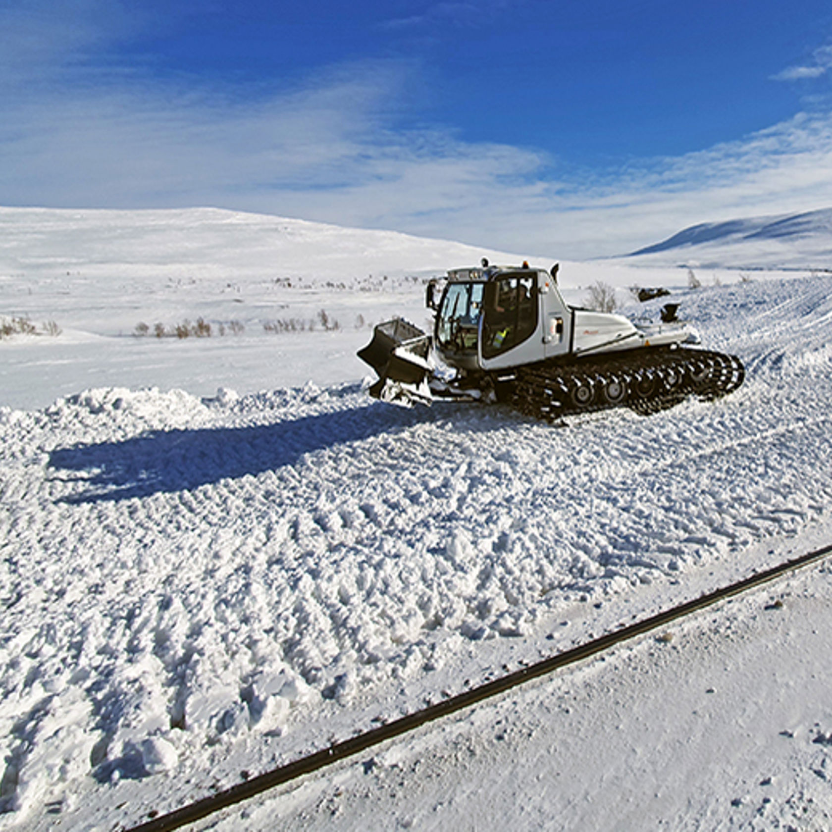 Bilde av en tråkkemaskin ved et jernbanespor på Saltfjellet.