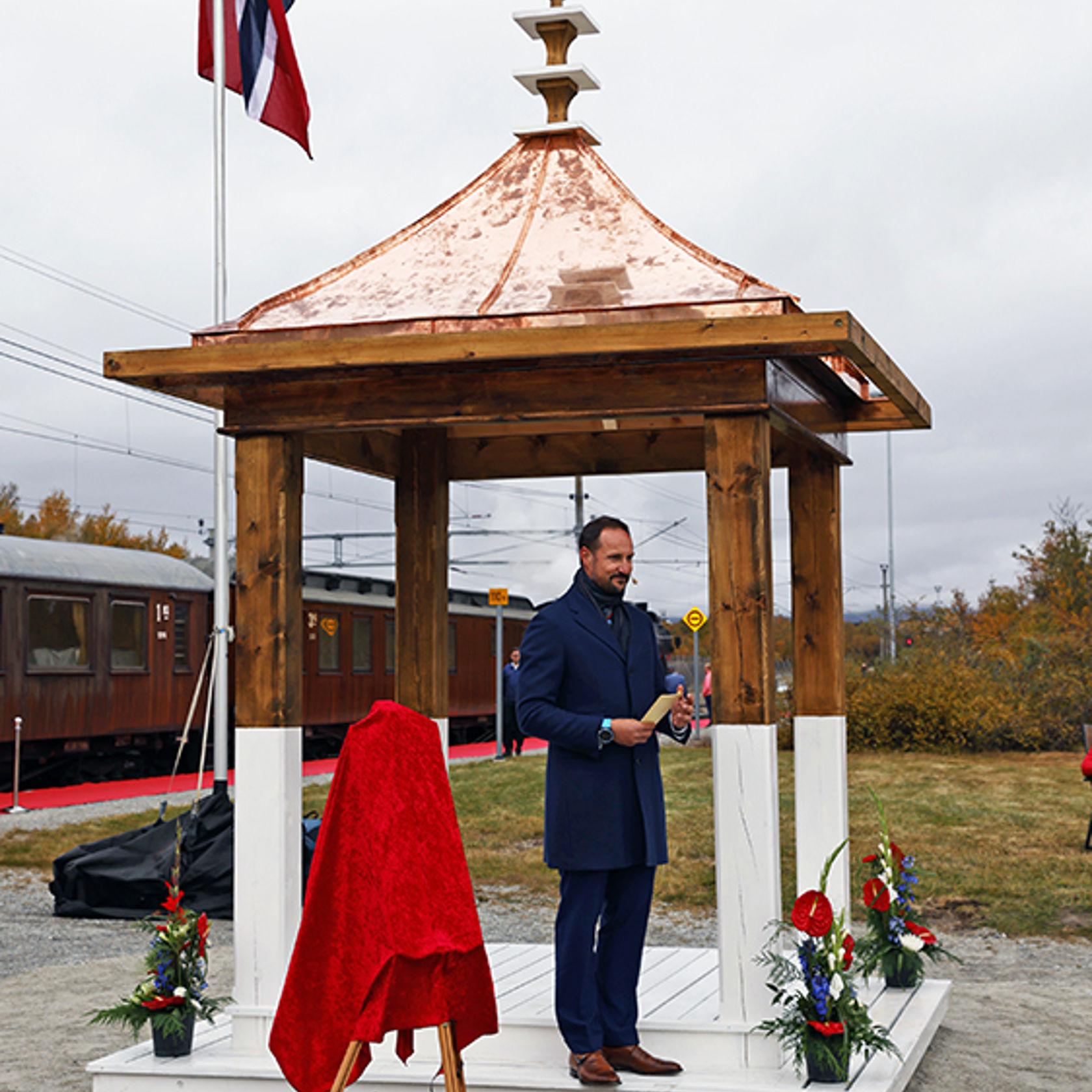 HKH Kronprins Haakon holder tale i Hjerkinn stasjons gjenoppbygde paviljong med kobbertak. 