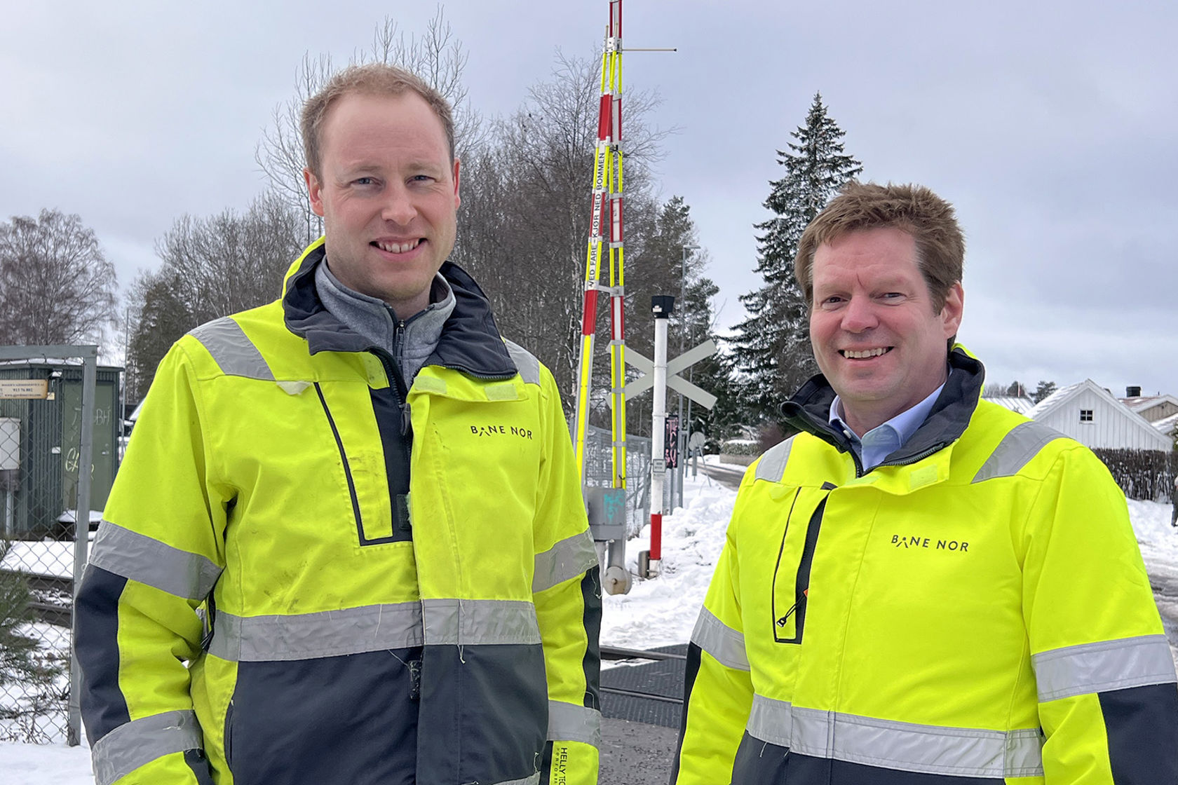 De to personene i gule Bane NOR-jakker foran Nordby planovergang