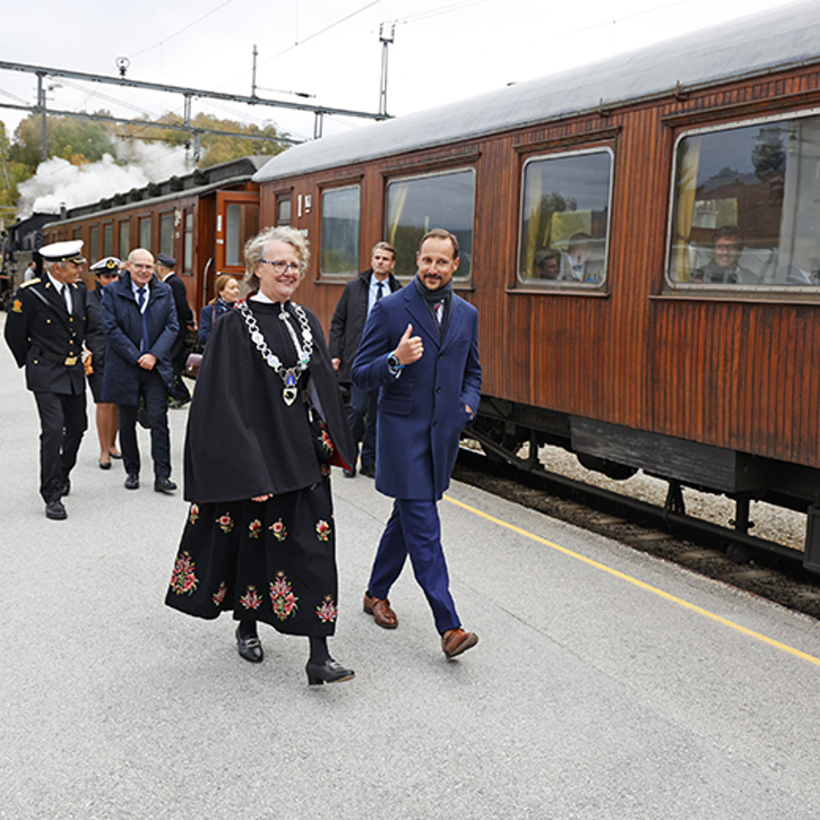 HKH Kronprins Haakon og Dovres ordfører Guri Ruste i hyggelig samtale på Dombås stasjon.