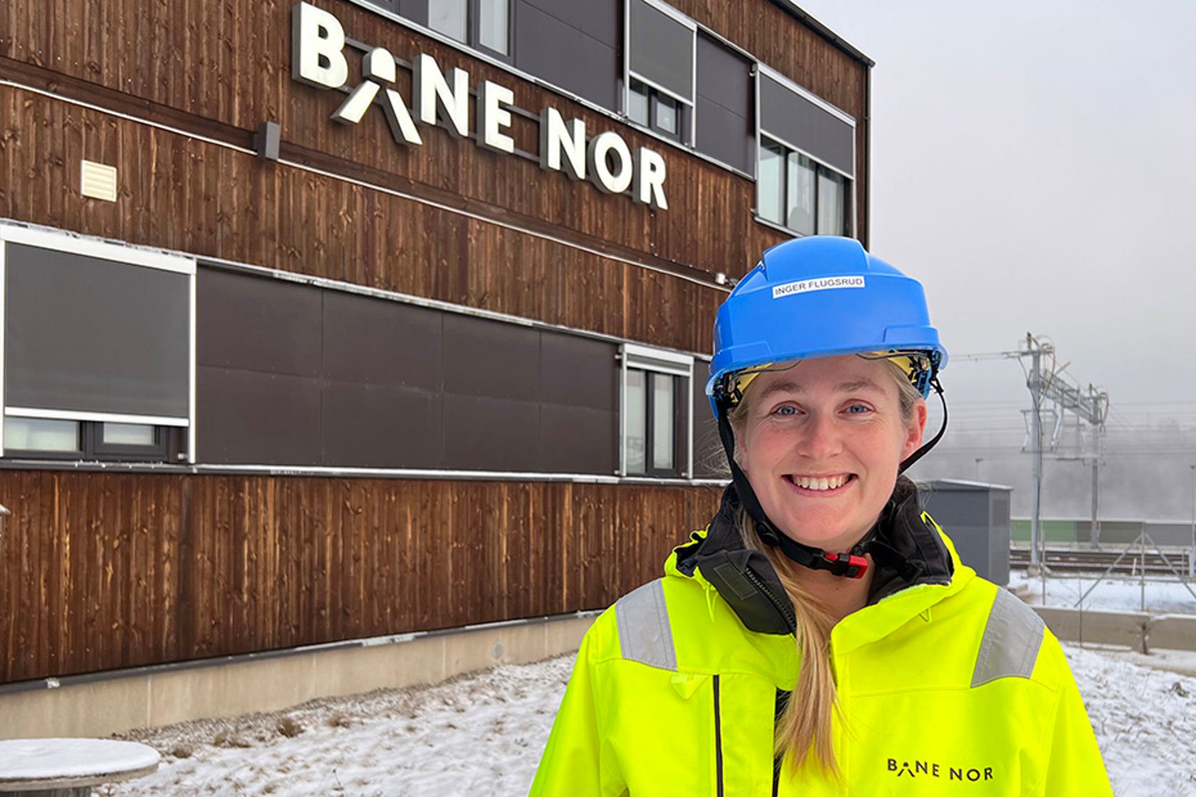 Inger med hjelm og vernetøy foran Bane NORs brakkerigg på Eidsvoll.