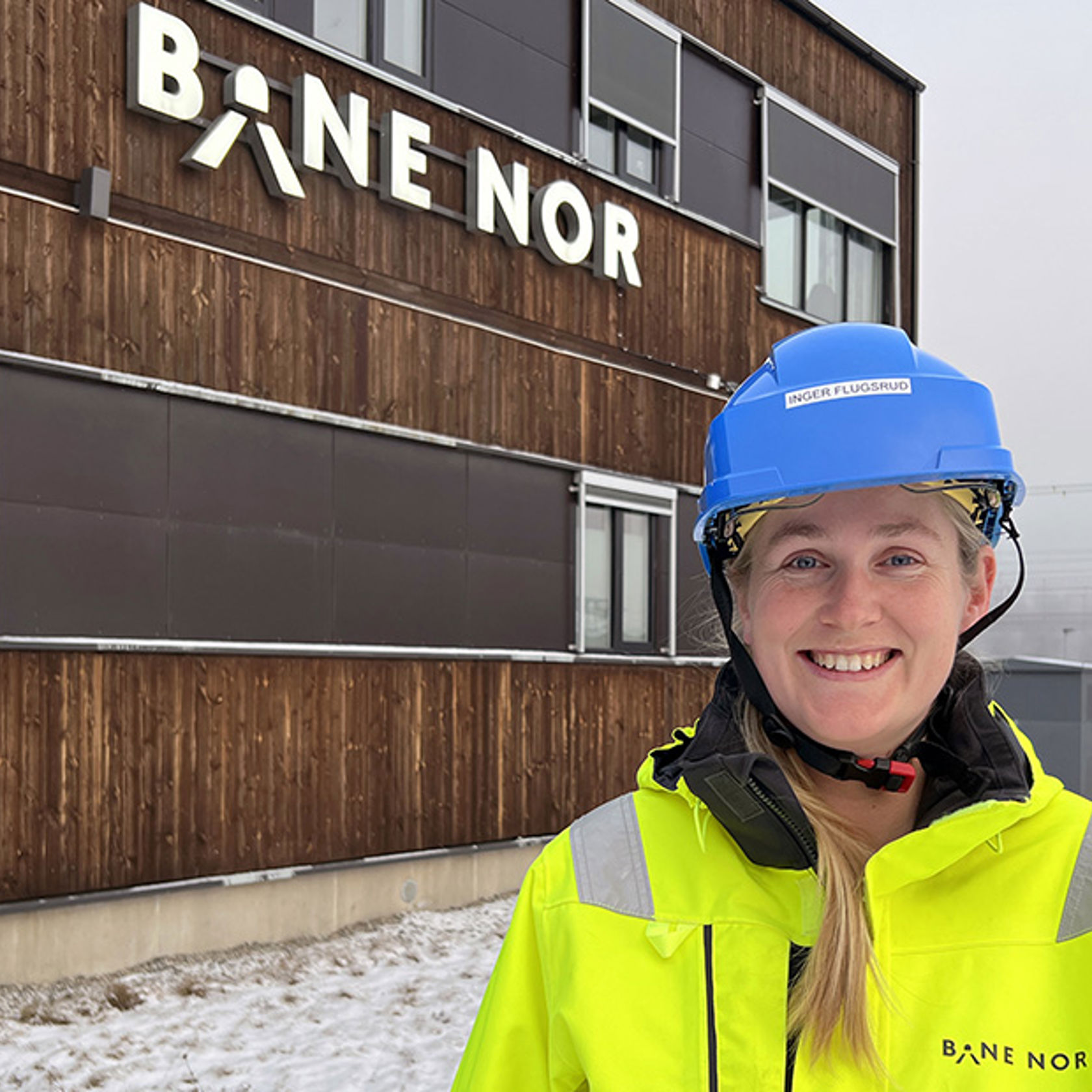 Inger med hjelm og vernetøy foran Bane NORs brakkerigg på Eidsvoll.