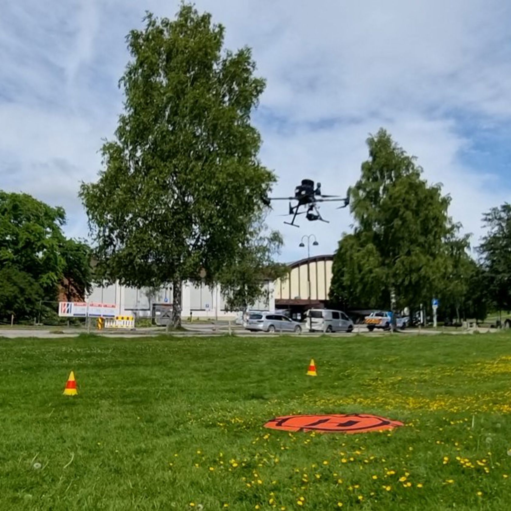 Mann i vernetøy og drone i lufta foran ham.