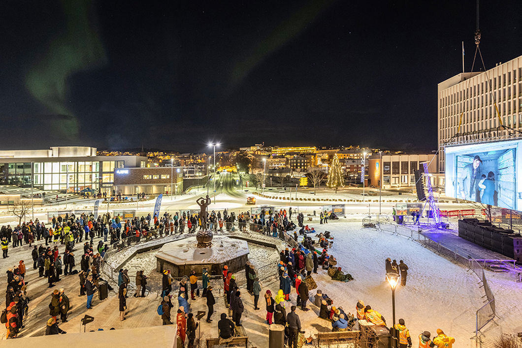 Bilde fra et torg der mange mennesker er samlet og ser mot en storskjerm.