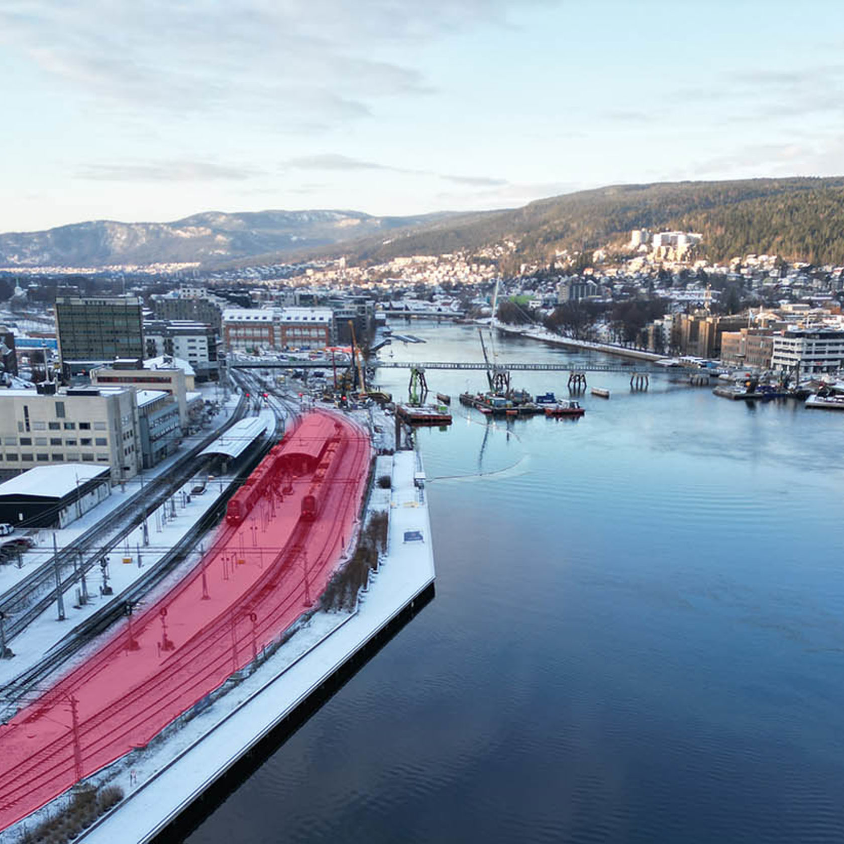 Oversiktsbilde over Drammenselva , stasjonen og deler av byen. 