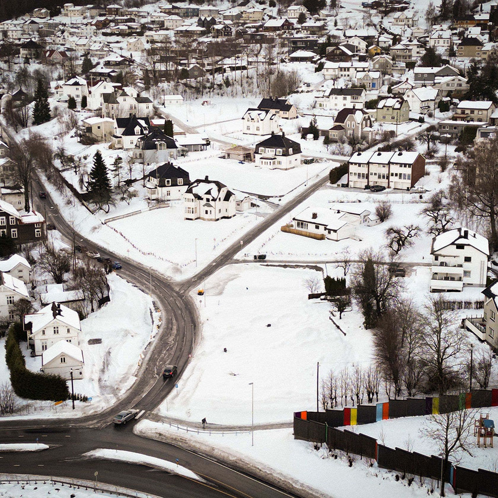 Vinterkledd boligområde med mange eneboliger fotografert med drone.