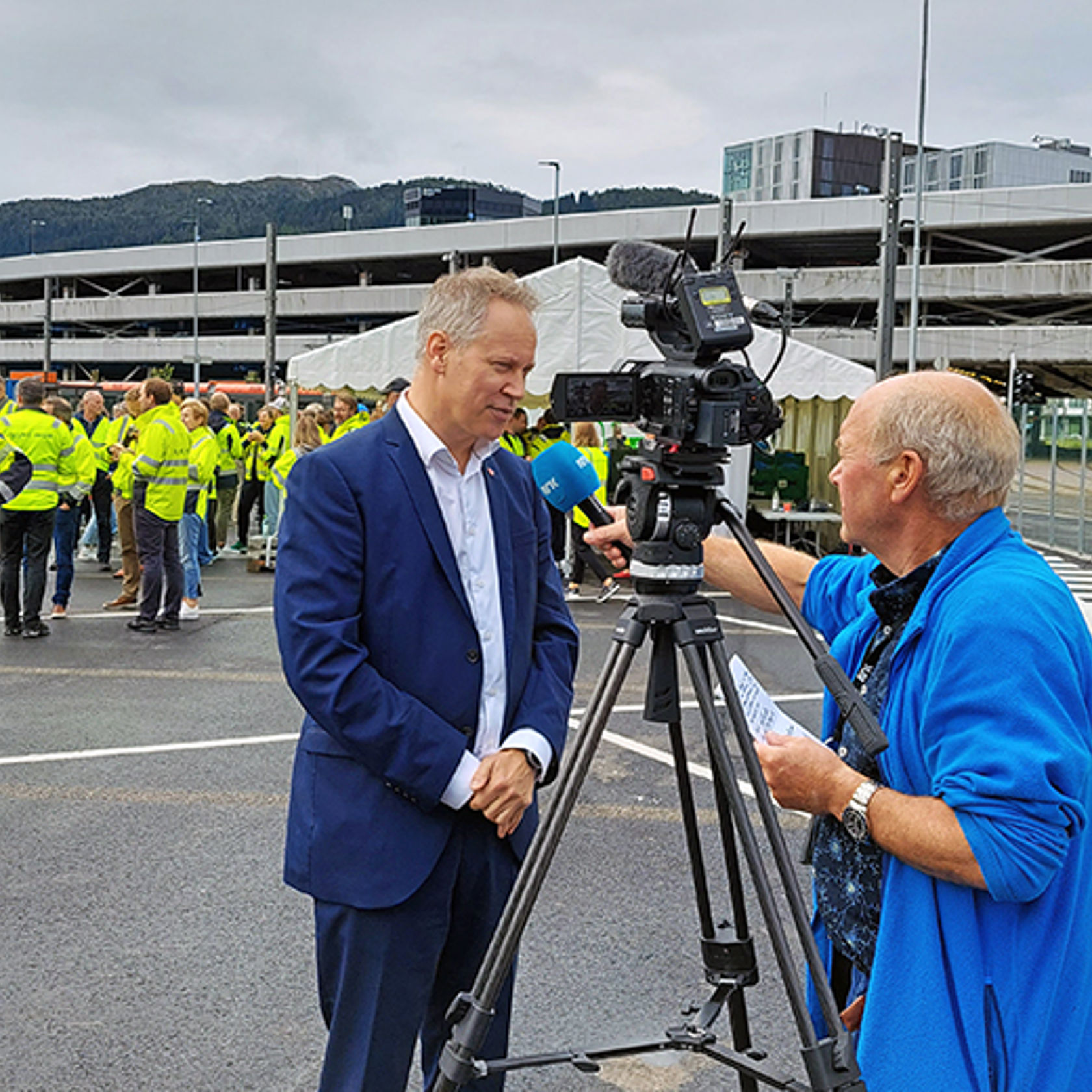 Mann i dress blir intervjuet av mann med TV-kamera.