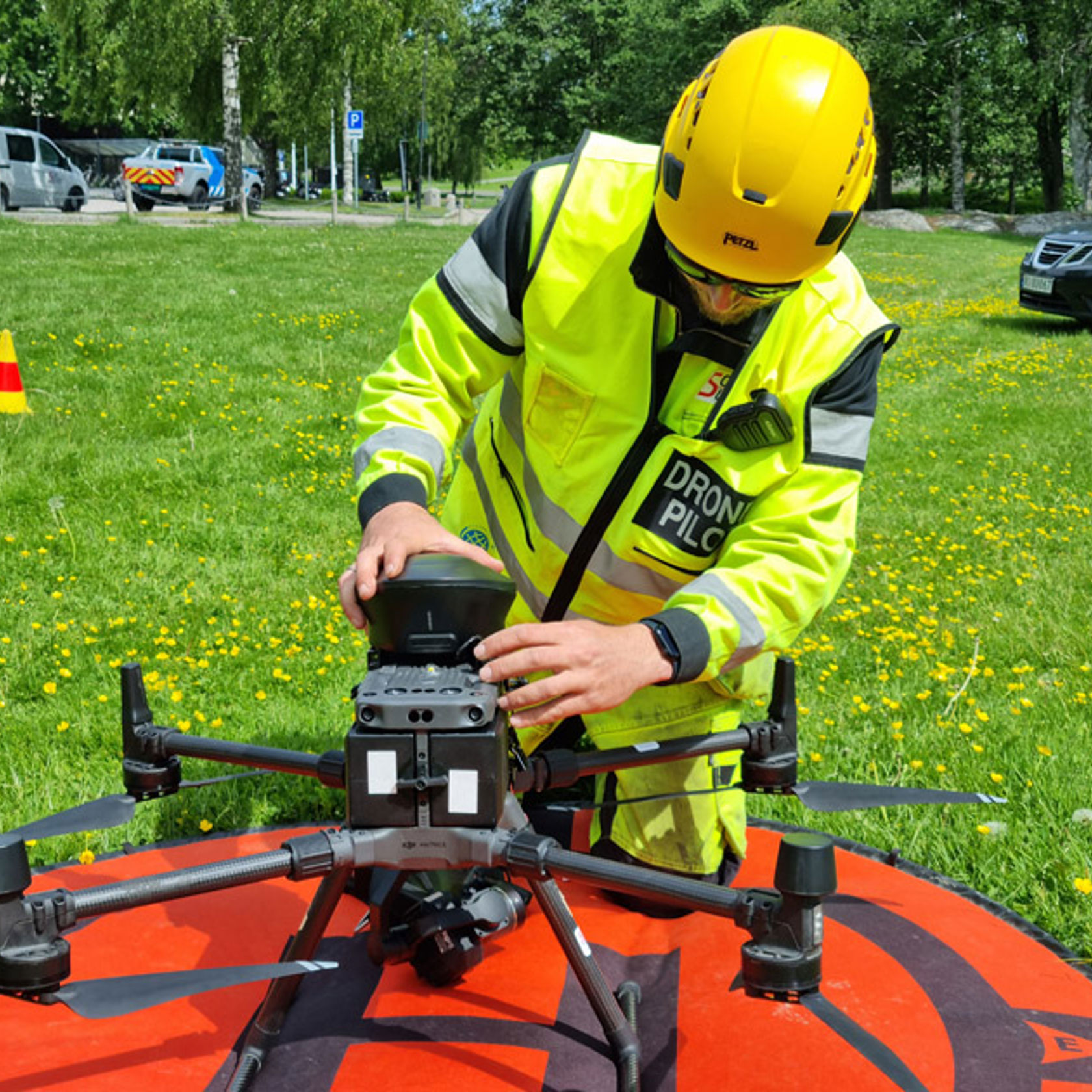 Mann i vernetøy justerer droneverktøy